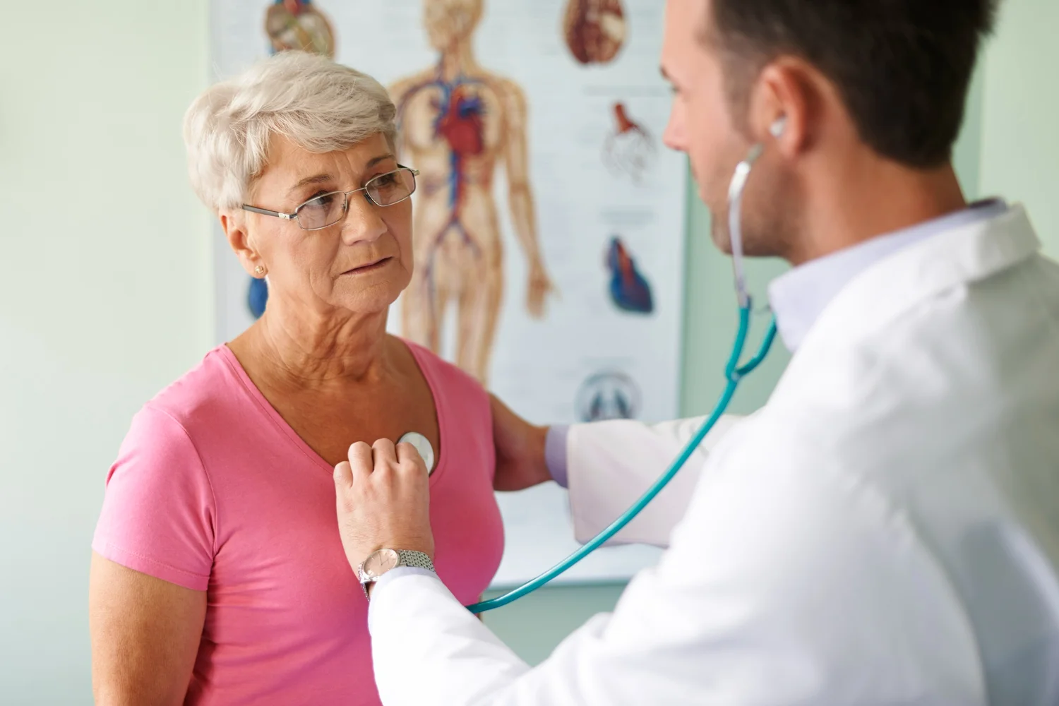 Médico cardiologista examinando coração de idosa com um estetoscópio para check-up cardiológico