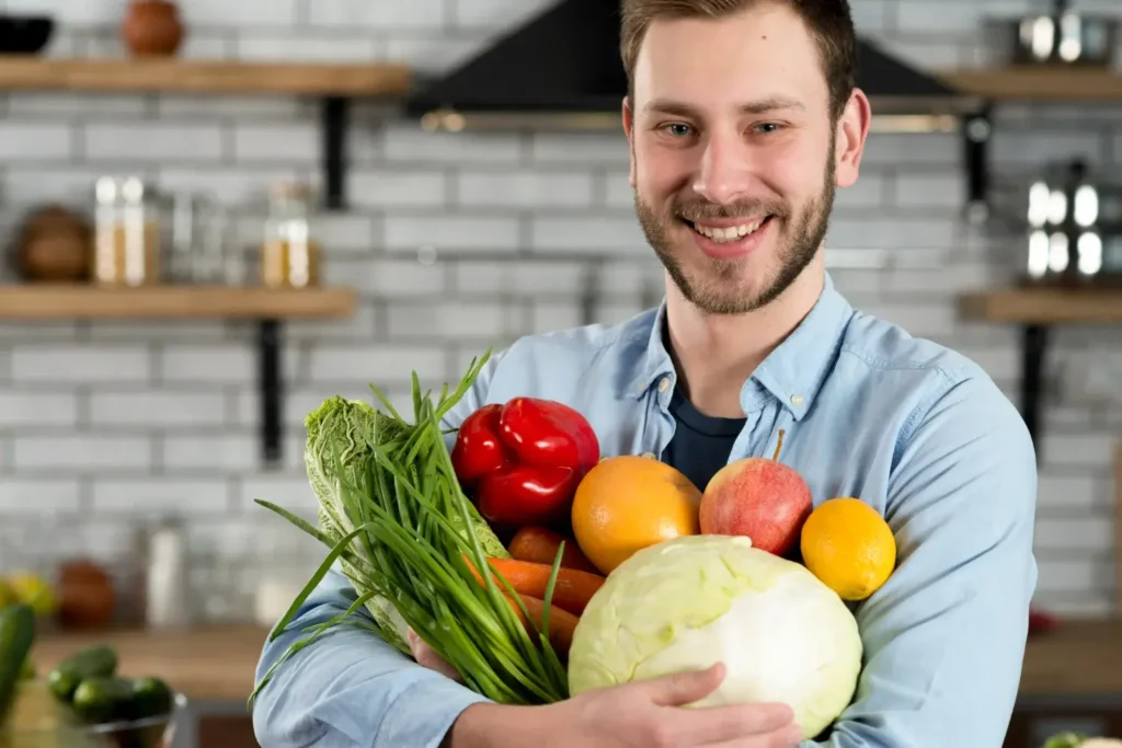 Homem na cozinha segura legumes, frutas e vegetais essenciais para alimentação saudável para coração