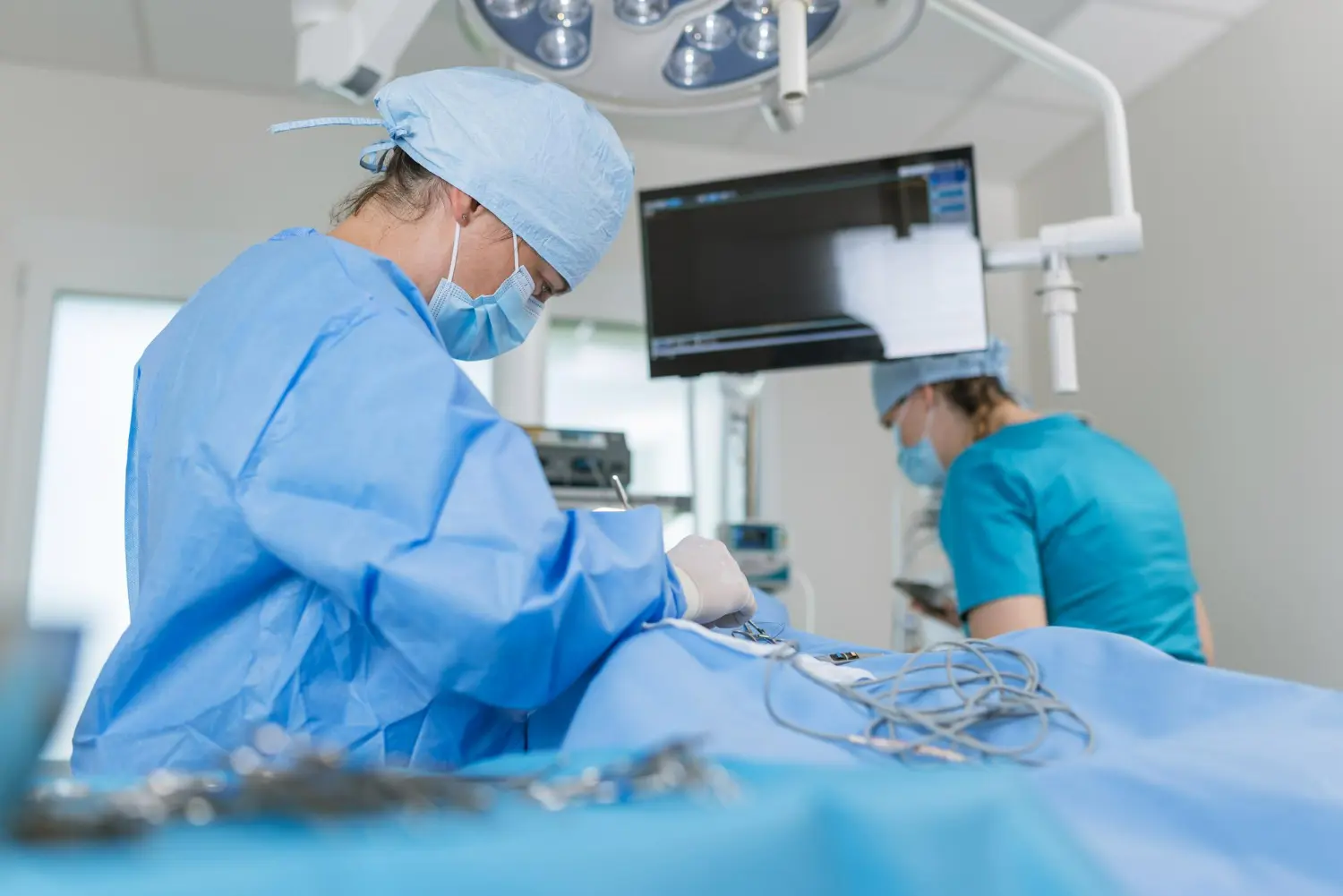 Médicos uniformizados trabalhando em sala de operação durante uma cirurgia cardíaca