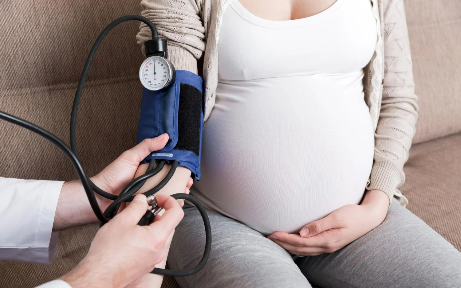 Médico medindo a pressão arterial de mulher grávida para diagnosticar hipertensão gestacional