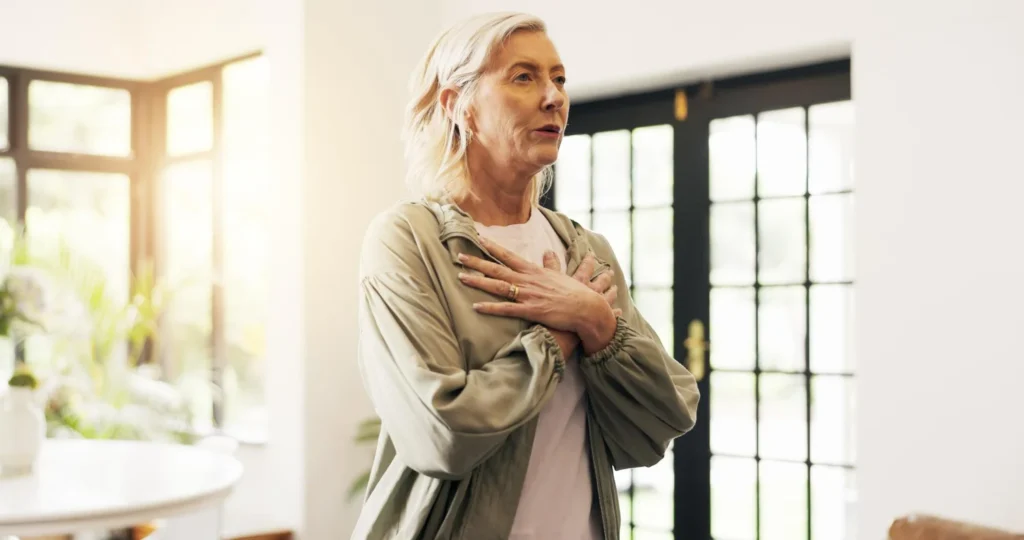 Idosa coloca as mãos no coração ao sentir um sopro no coração