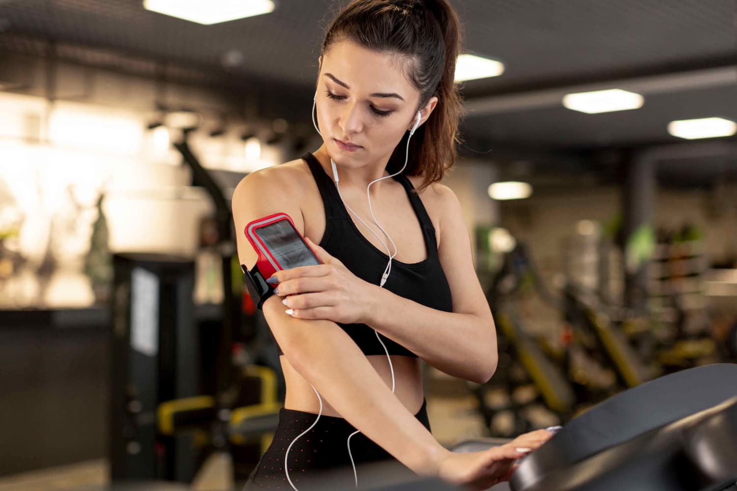 Mulher medindo frequência cardíaca no treino enquanto corre na esteira